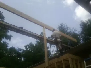 Carpenter setting a ridge beam over a new addition frame — Ice Dam Removal by Roofing Brothers in Bullard