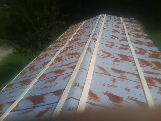 Rusted metal roof panels with new wood purlins before replacement — Storm Damage Roof Repair in Bullard by Roofing Brothers