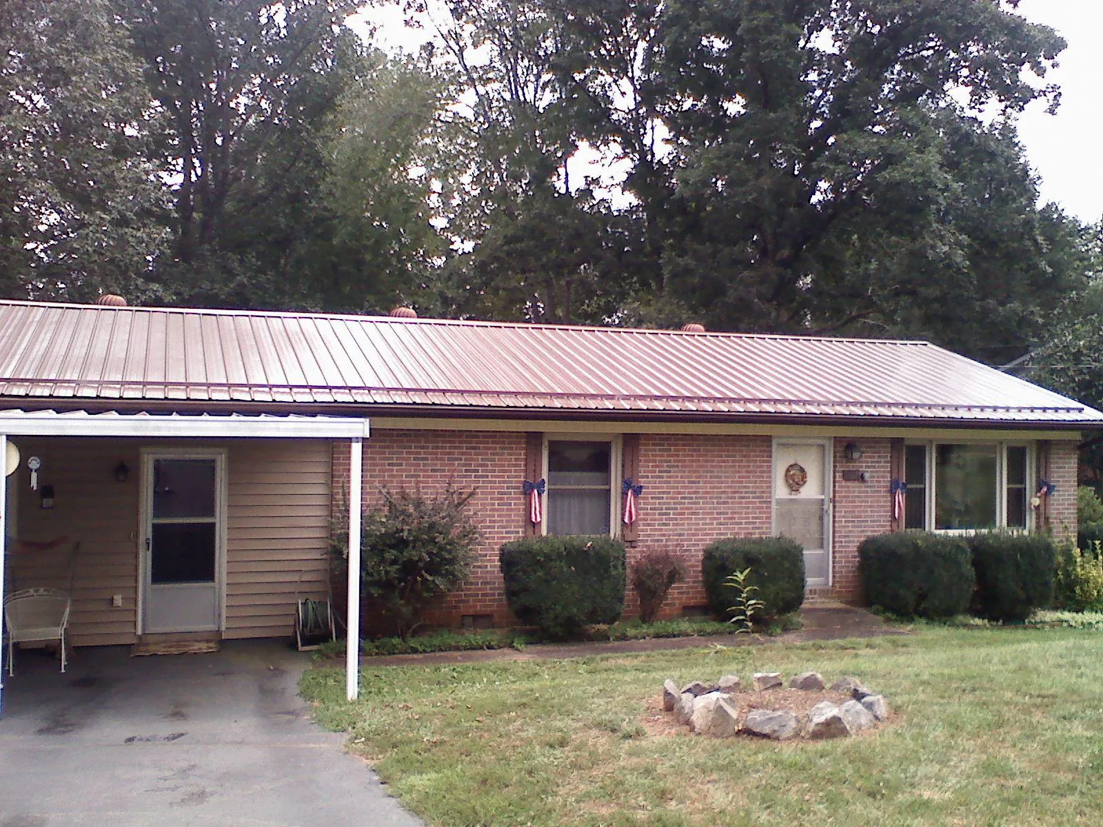 Bronze metal roof and carport on a brick ranch home — Roof Repair work by our crew in Bullard