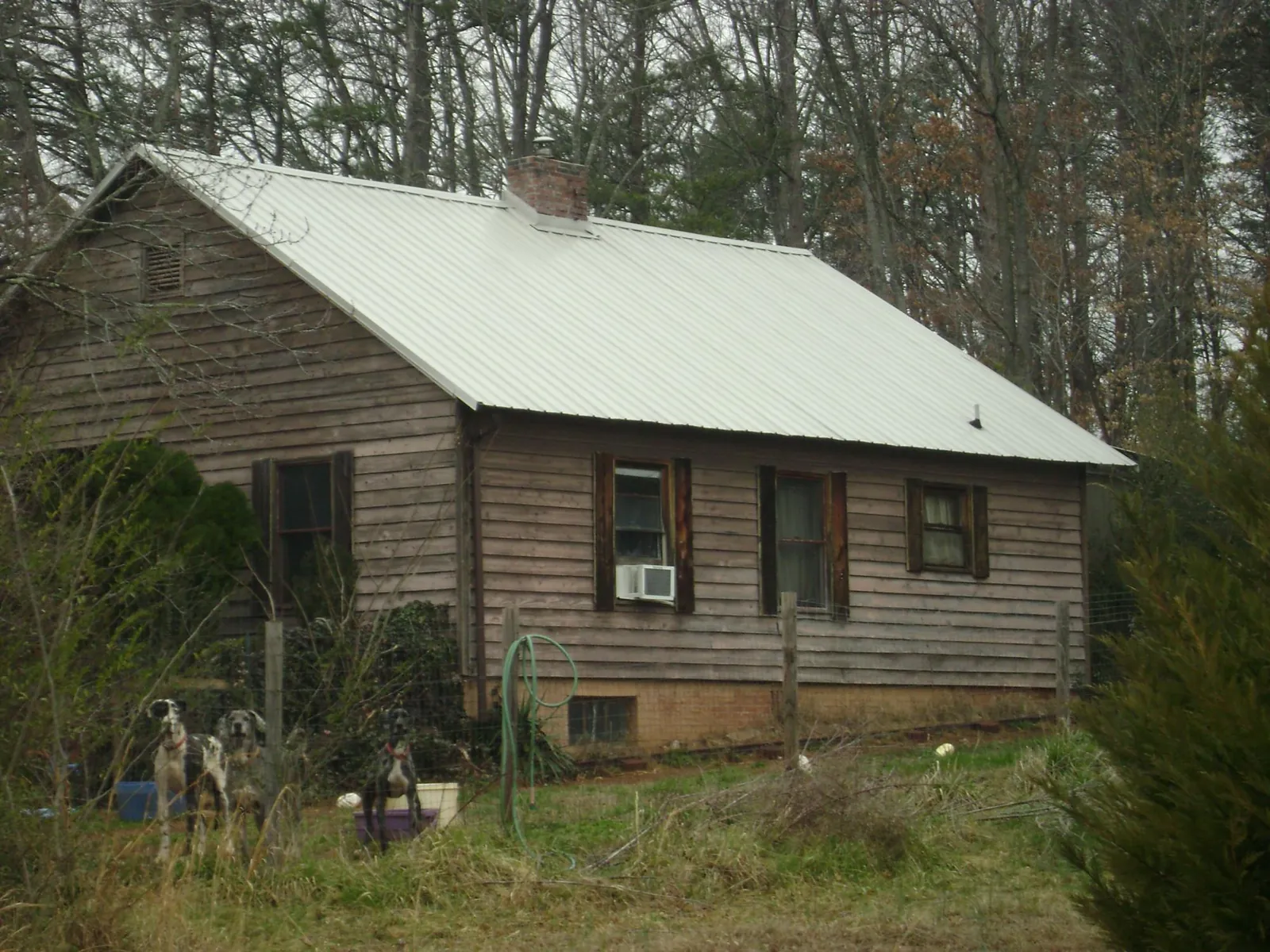 White metal roof on an old wood sided farmhouse, from a Metal Roof Installation job in Bullard